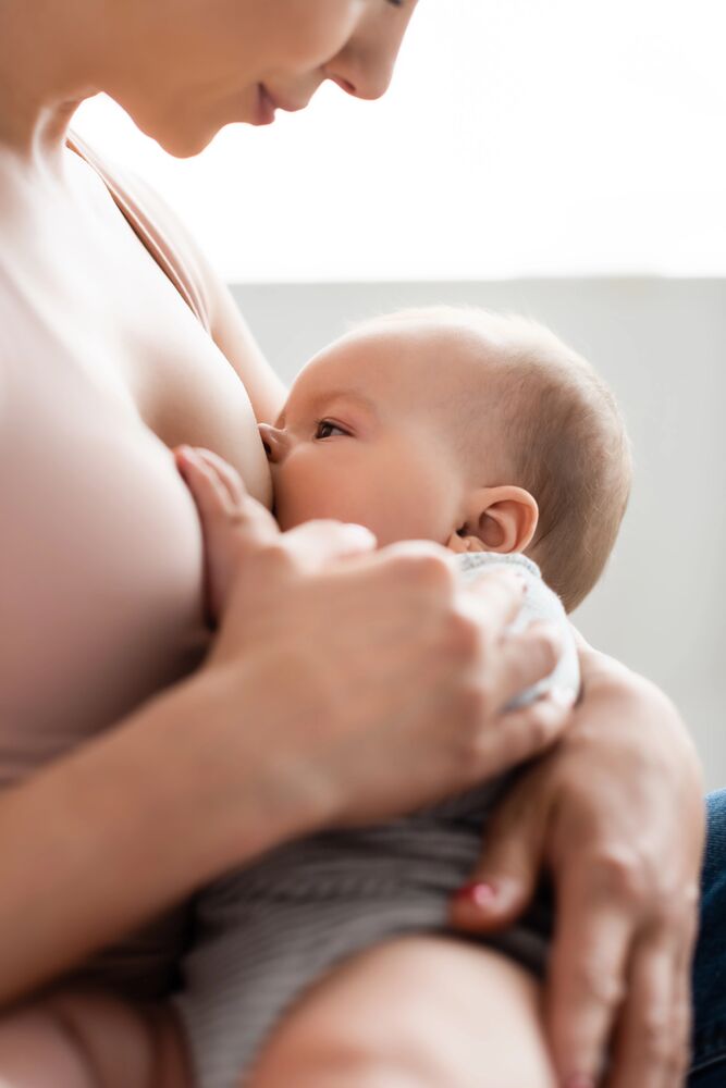 Mamma che allatta con assistenza professionale